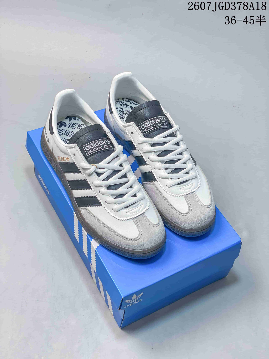 Pair of white, black, and gray low-top Adidas sneakers displayed on a blue shoebox; overlay text shows 36–45 sizing.