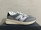 Side view of a gray New Balance U370 sneaker with a large light-colored logo.