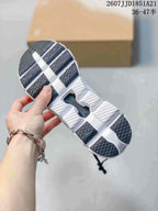 Underside view of the sneaker showing the segmented outsole, textured dark traction sections, and central open channel.