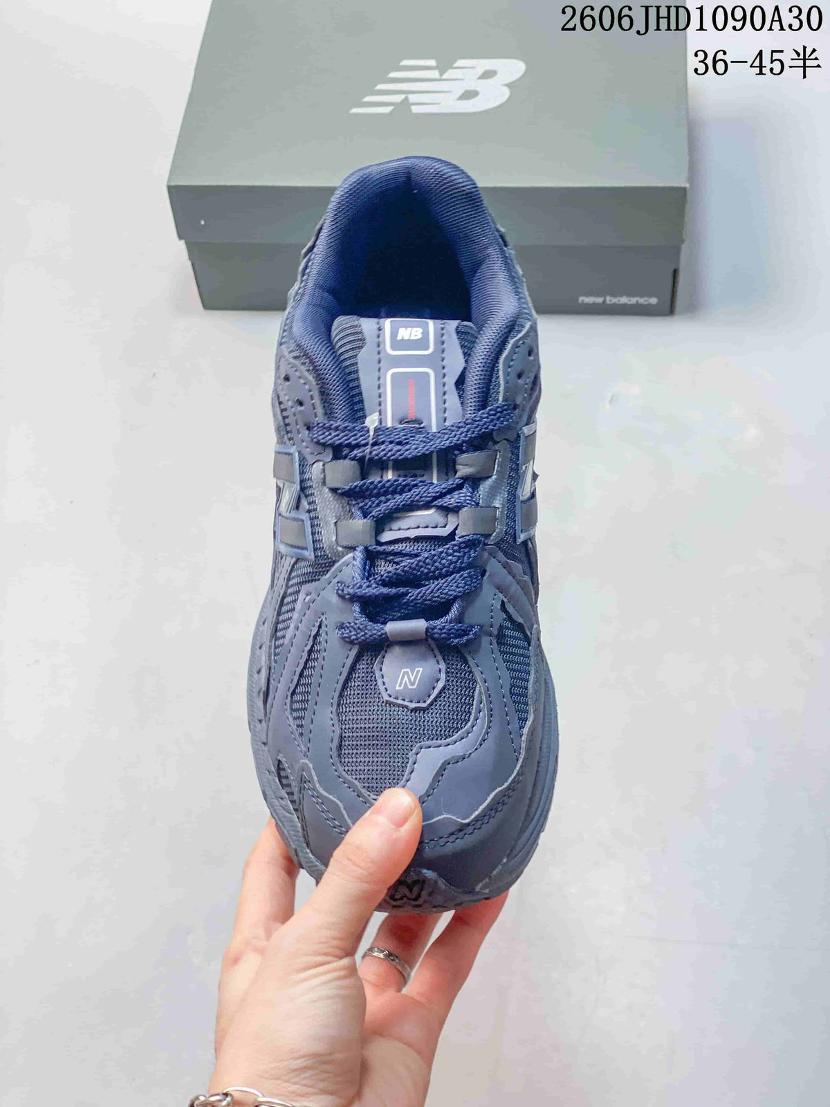 Top-down view of the mesh toe and lace-up front of a blue-gray New Balance sneaker.