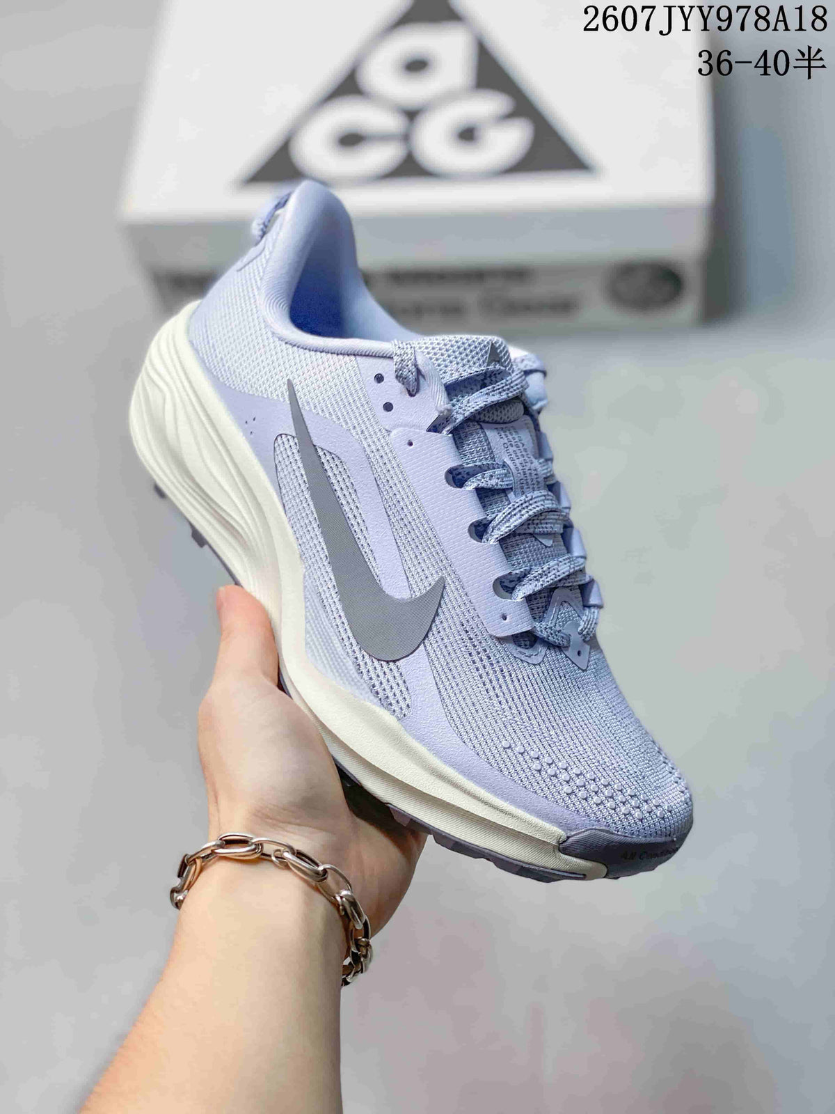 Three-quarter side view of a light lavender Nike ACG Pegasus Trail sneaker with a gray Nike Swoosh and cream-colored midsole.