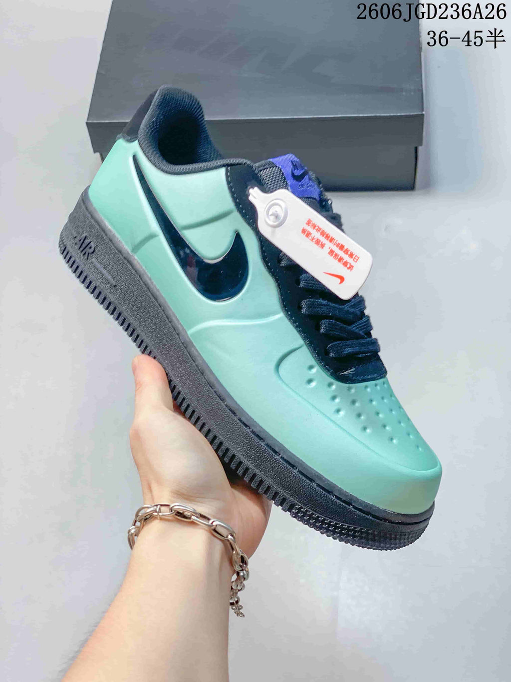 Angled side view of the mint-green and navy low-top sneaker