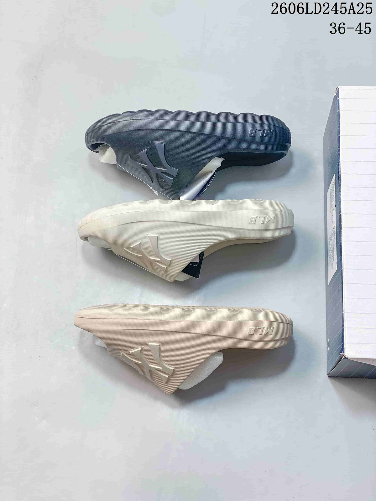 Side profiles of dark navy and light-colored slide sandals showing the molded soles.