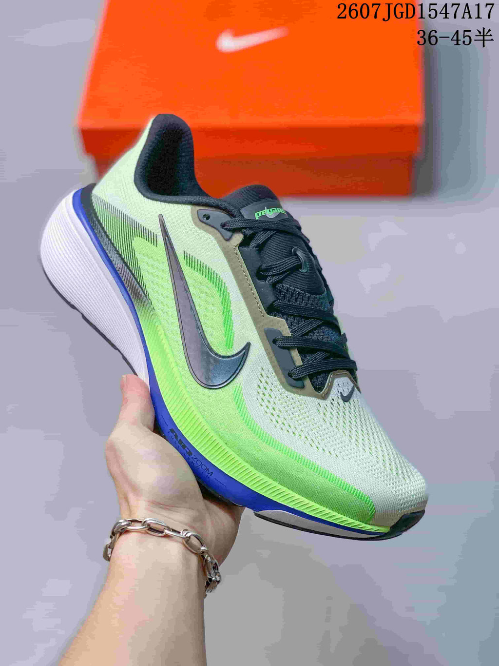 Three-quarter side view of the sneaker showing the pale green mesh-style upper, black Swoosh, blue accent, and white midsole.