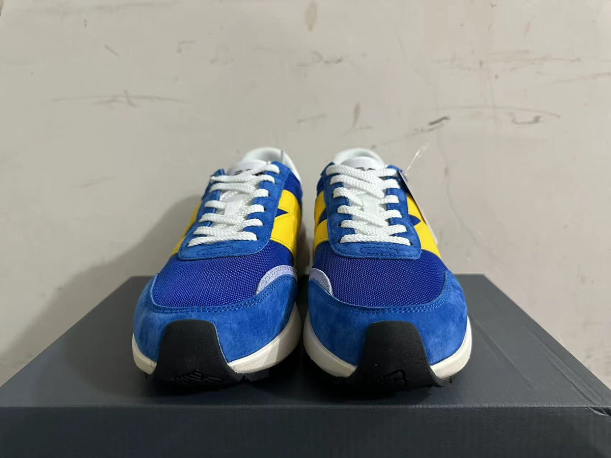 Front view of blue and yellow New Balance U370 sneakers with white laces
