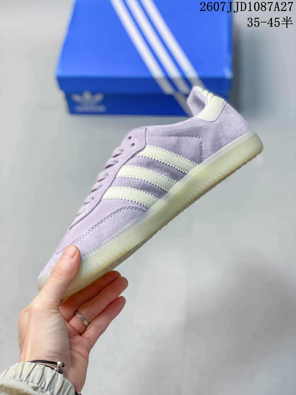 Side profile highlighting the lavender upper, cream three-stripe design, and low-profile outsole.