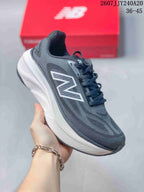 Angled side view showing the dark gray New Balance running shoe, white midsole, lace-up design, and contrasting logo.