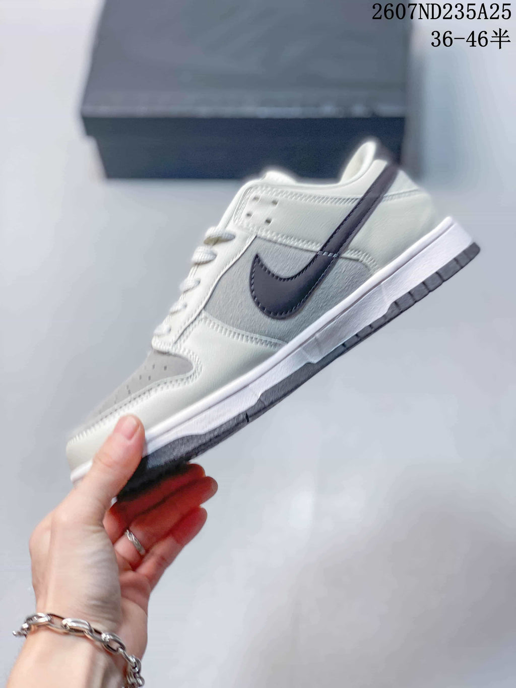 Side profile showing the low-top shape, dark swoosh, white upper panels and grey outsole accents.