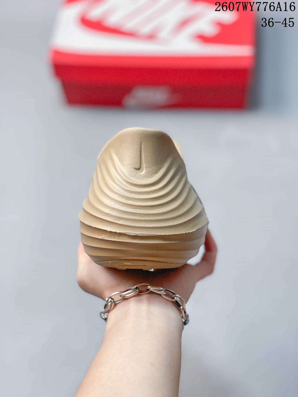 Rear view of the tan clog showing the raised heel area and layered sculpted ridges.