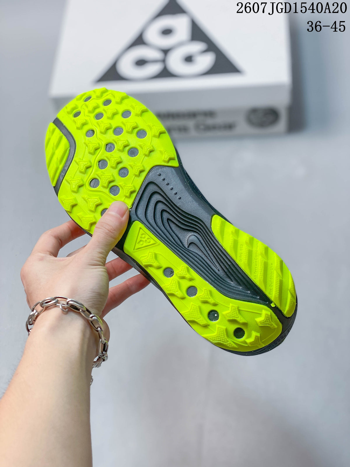 Bottom view showing the neon green patterned outsole and dark midsole of a Nike ACG Pegasus Trail sneaker.
