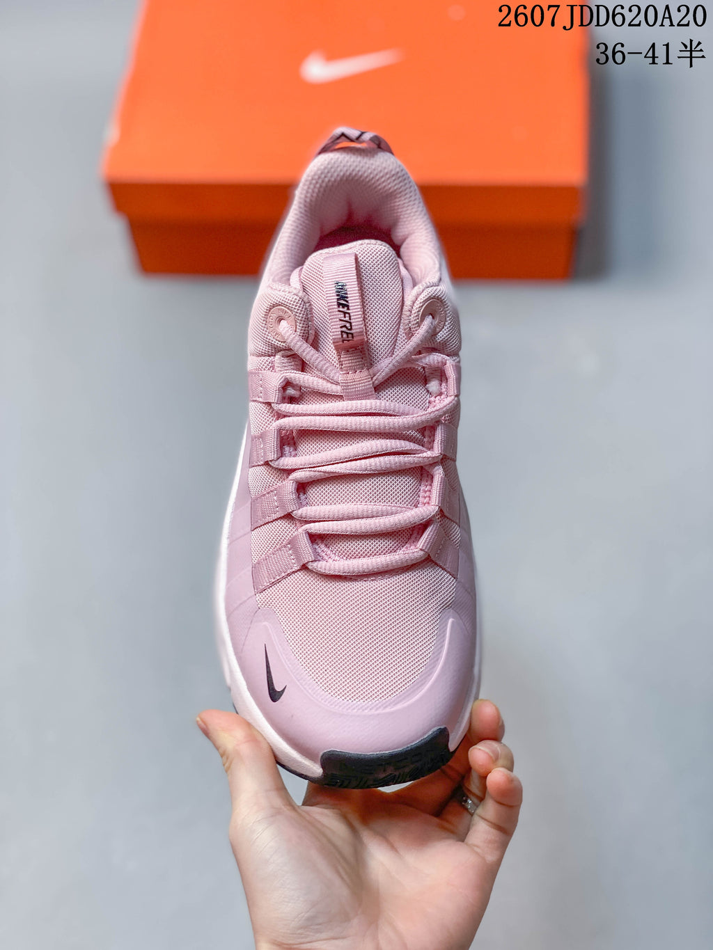 Top view of the pink training shoe showing the mesh-like toe area, layered laces, padded tongue, and dark toe detail.