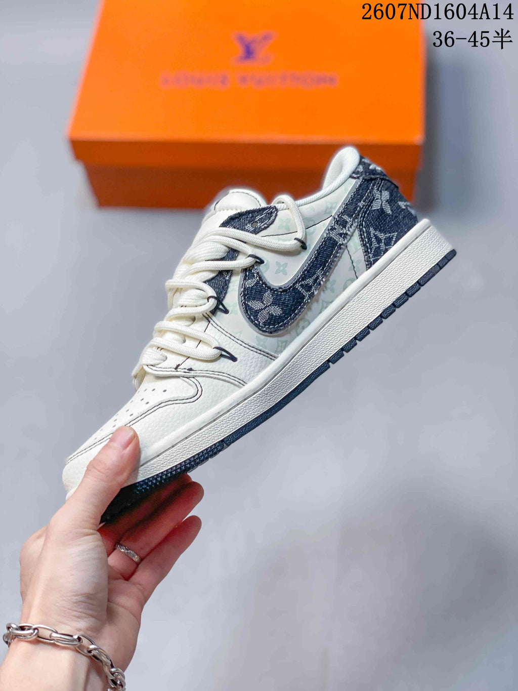 Side profile of a white and grey low-top sneaker with patterned panels, a dark contrasting side detail, and a white midsole.