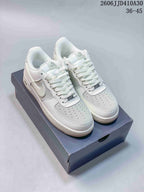 Pair of white Nike Air Force 1 '07 Low sneakers with light neutral accents on a shoebox