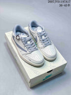 Pair of white and grey low-top Jordan sneakers displayed on a branded shoe box.