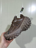 Side view of a coffee-brown chunky sneaker showing the mesh upper, layered side panels, and thick lugged outsole.