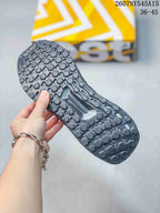 Close-up of the patterned outsole on a dark gray sneaker, showing rounded traction elements and the molded midfoot section.
