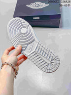 Close-up of the patterned outsole on a white and grey low-top sneaker