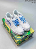 Pair of white A Bathing Ape STA low-top sneakers with blue laces and star details on a camouflage shoebox.