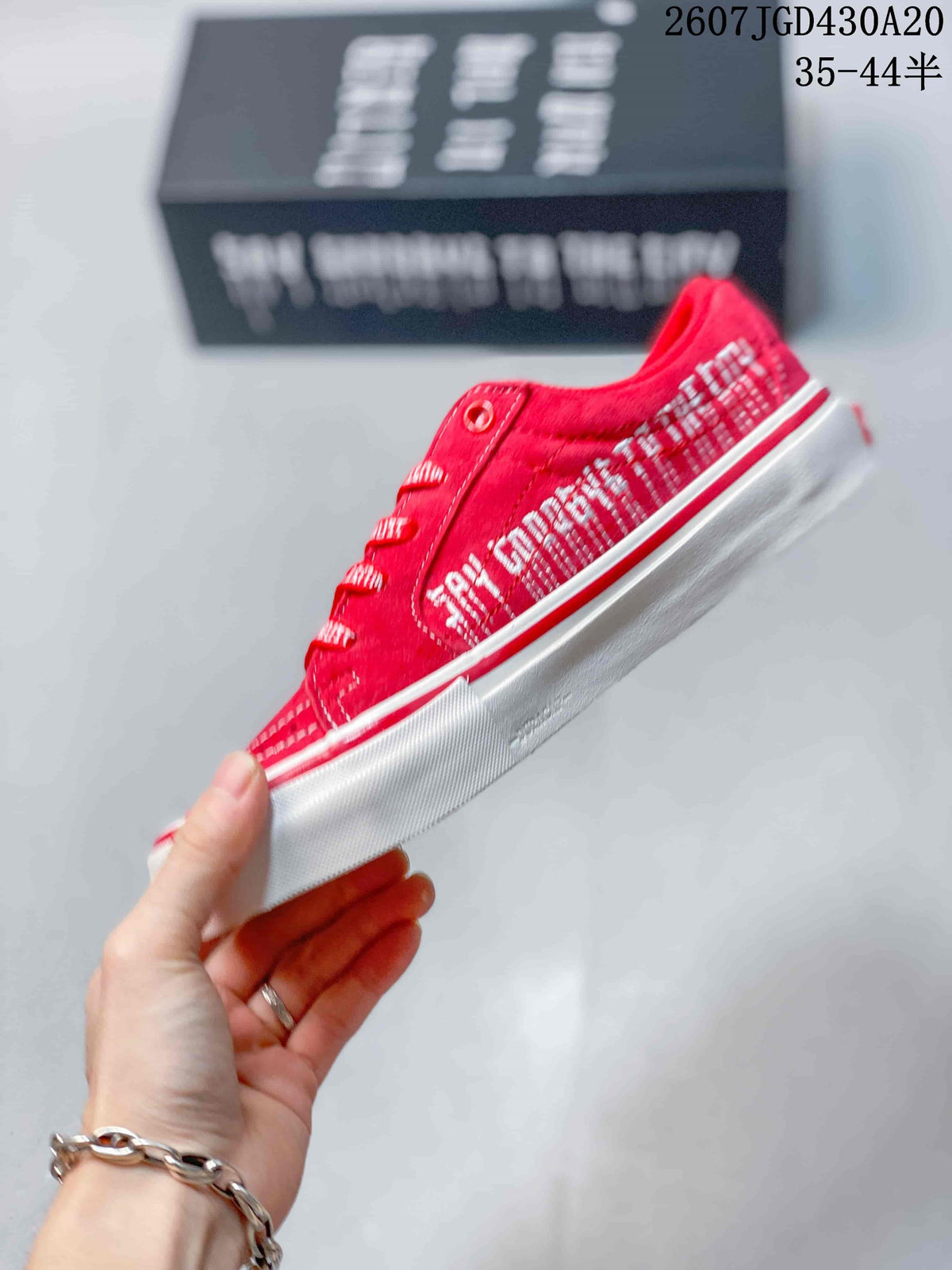 Side profile of the red low-top sneaker with white side stripe, patterned side detailing, and layered white sole.