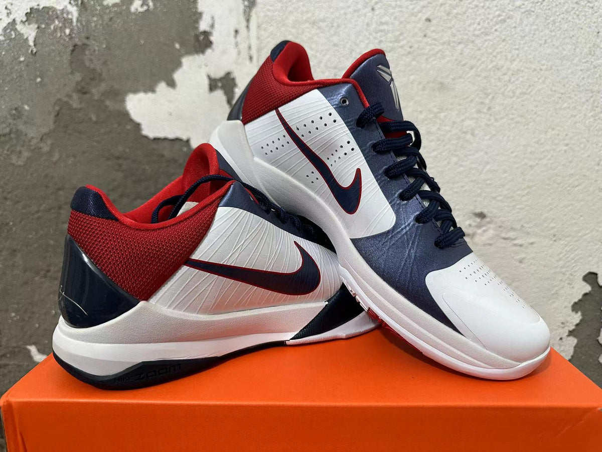 Pair of white, navy, and red Nike Kobe basketball shoes shown from multiple angles