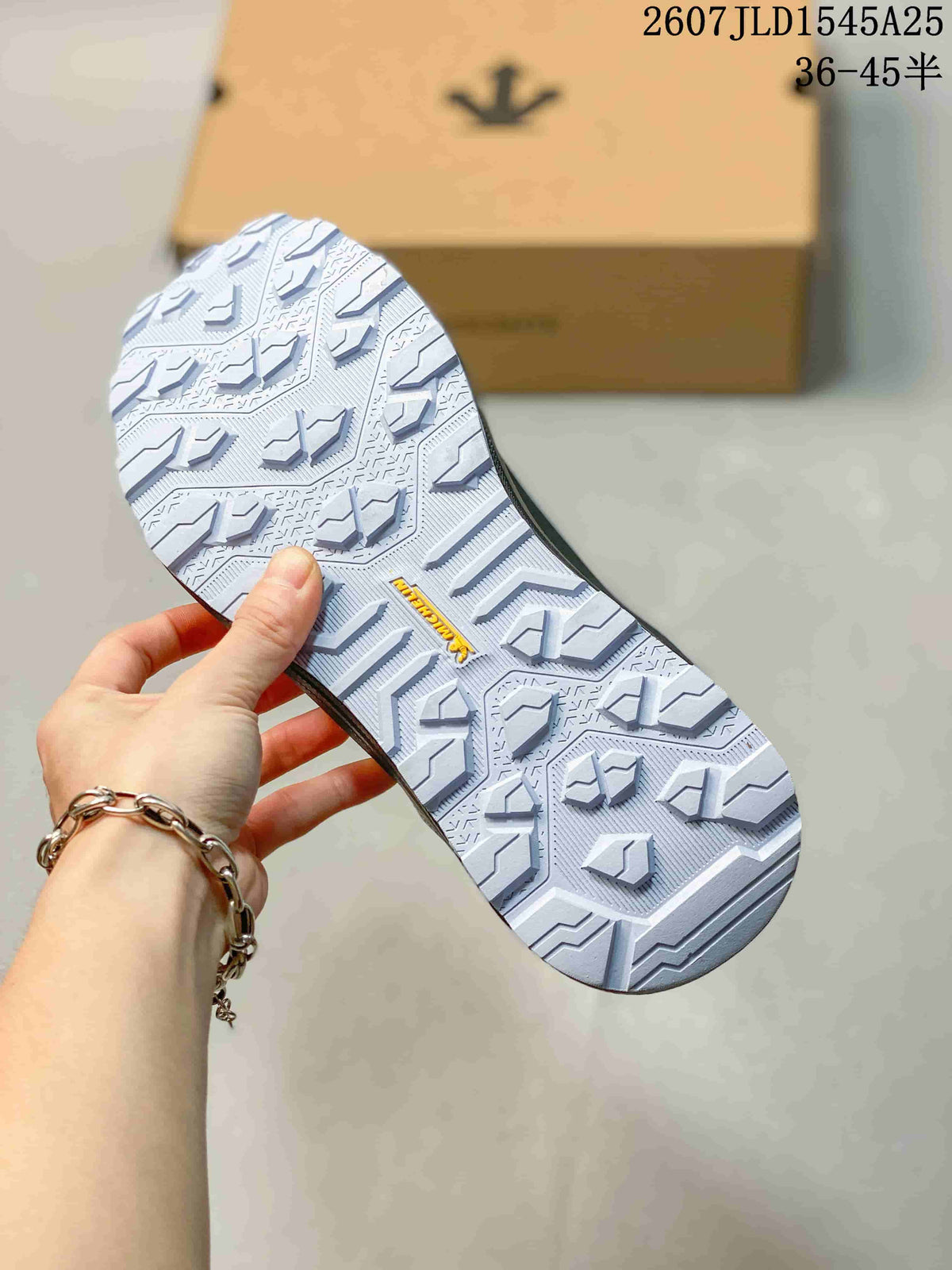 Close view of the sneaker outsole showing a light-colored patterned tread with raised traction blocks.