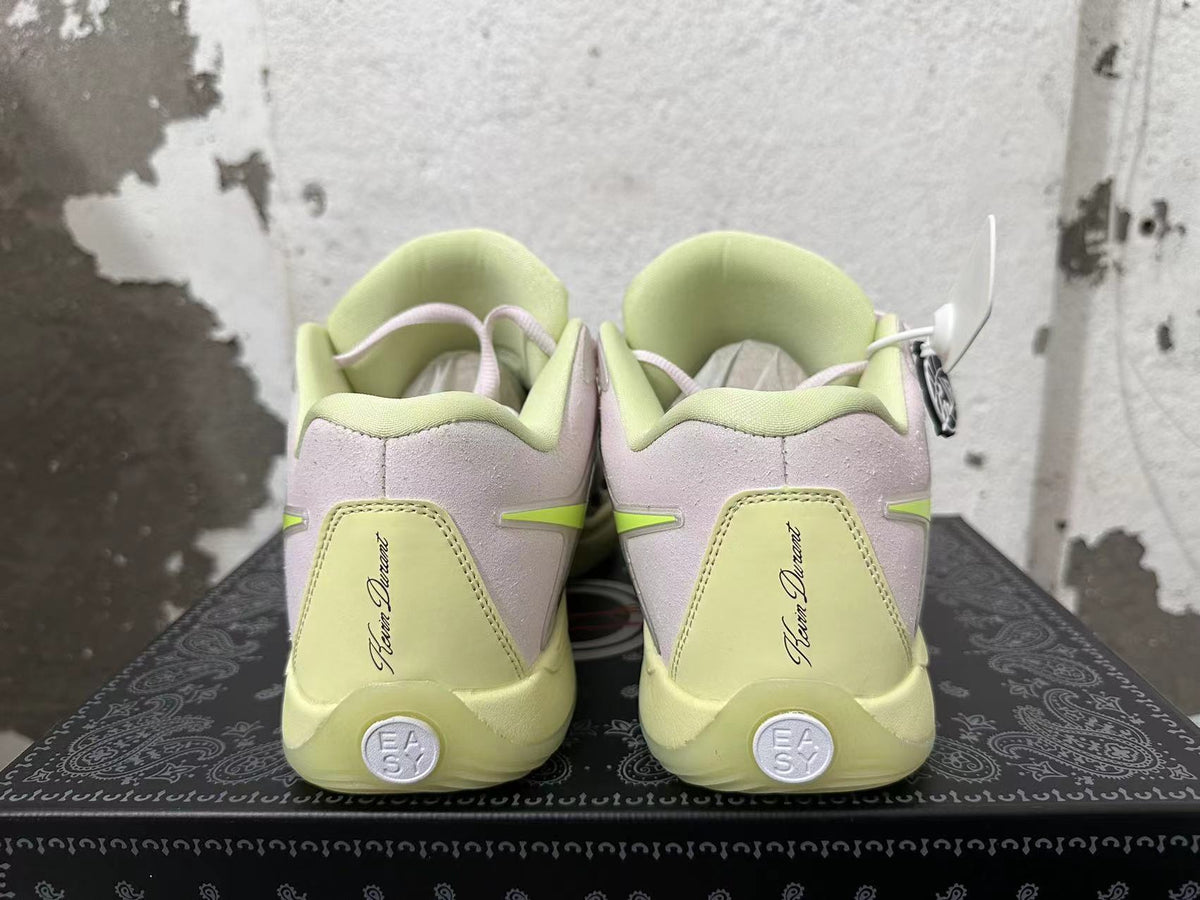Rear view of white and pale lime Nike basketball shoes with light purple heel panels.