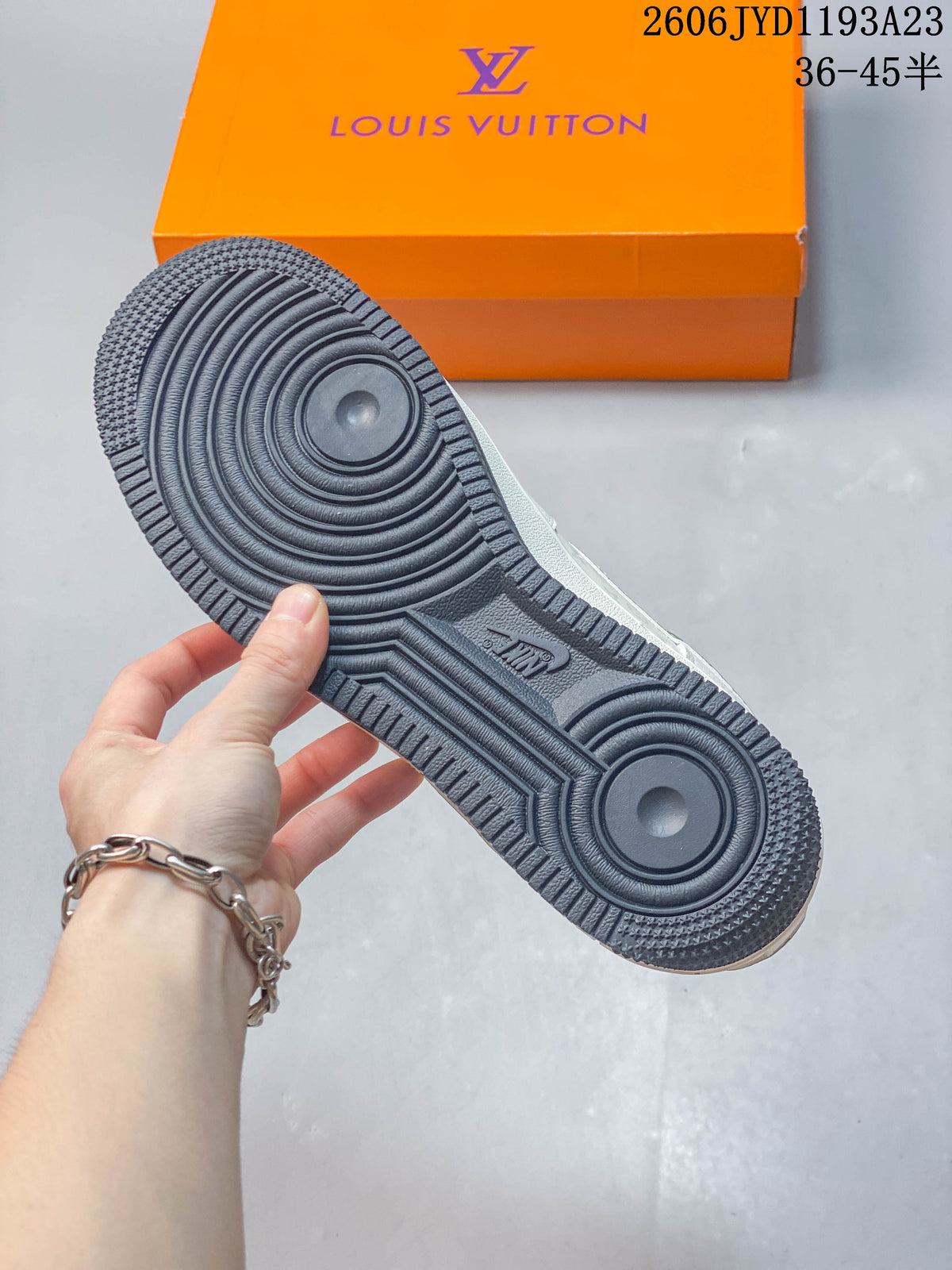 Close-up of the dark patterned outsole with an orange box in the background.