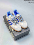 White and blue adidas Samba sneakers displayed on an adidas shoe box, with style code 2607JDD265A15 and size range text visible above.