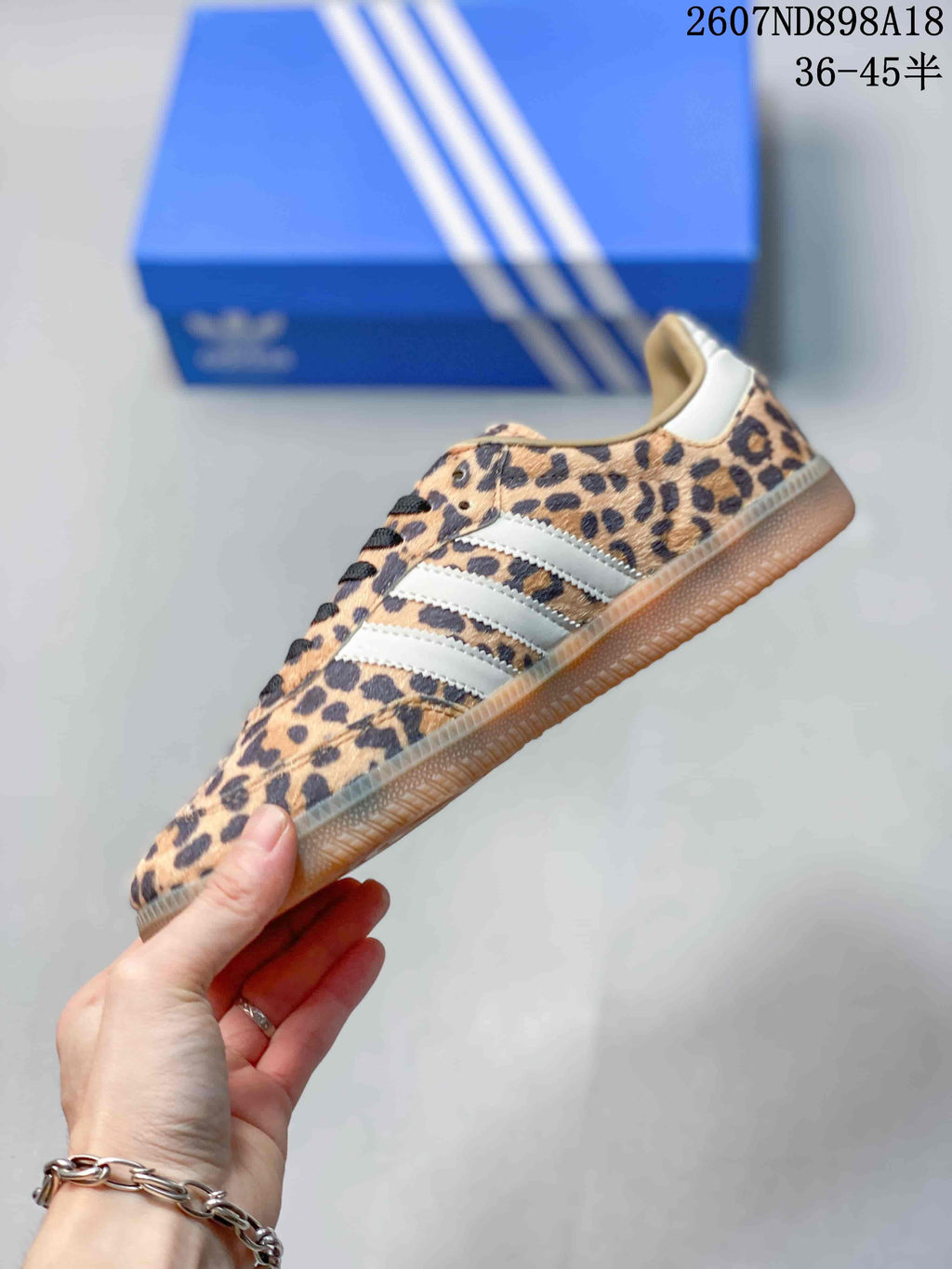 Side view showing the leopard-print upper, white three-stripe detailing, and low-profile gum outsole.