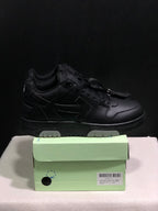Side view of a black low-top sneaker with layered panel detailing, tonal laces and light outsole sections; size 41 is visible on the box label.