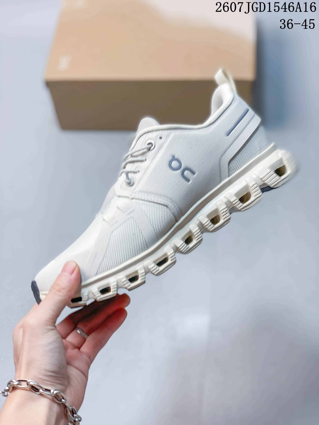 Side view of the white and grey On sneaker highlighting the layered upper and segmented sole.