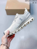 Side view of the white and grey On sneaker highlighting the layered upper and segmented sole.