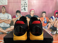 Rear view of yellow and black Nike basketball shoes with red heel accents