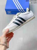 Side profile of the white low-top sneaker with dark stripes and textured toe overlay