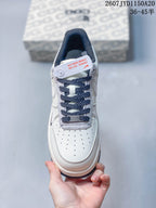 Top view of the sneaker showing the perforated toe box, navy laces, gray tongue trim and AF1 lace tag.