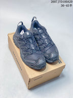 Pair of black Salomon XA PRO 3D trail running shoes displayed on a Salomon shoe box.