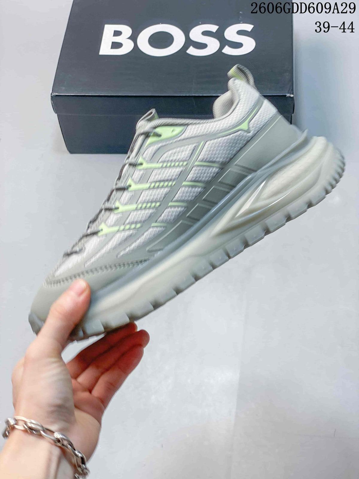 Side profile of a grey BOSS sneaker with lime accents and a chunky outsole