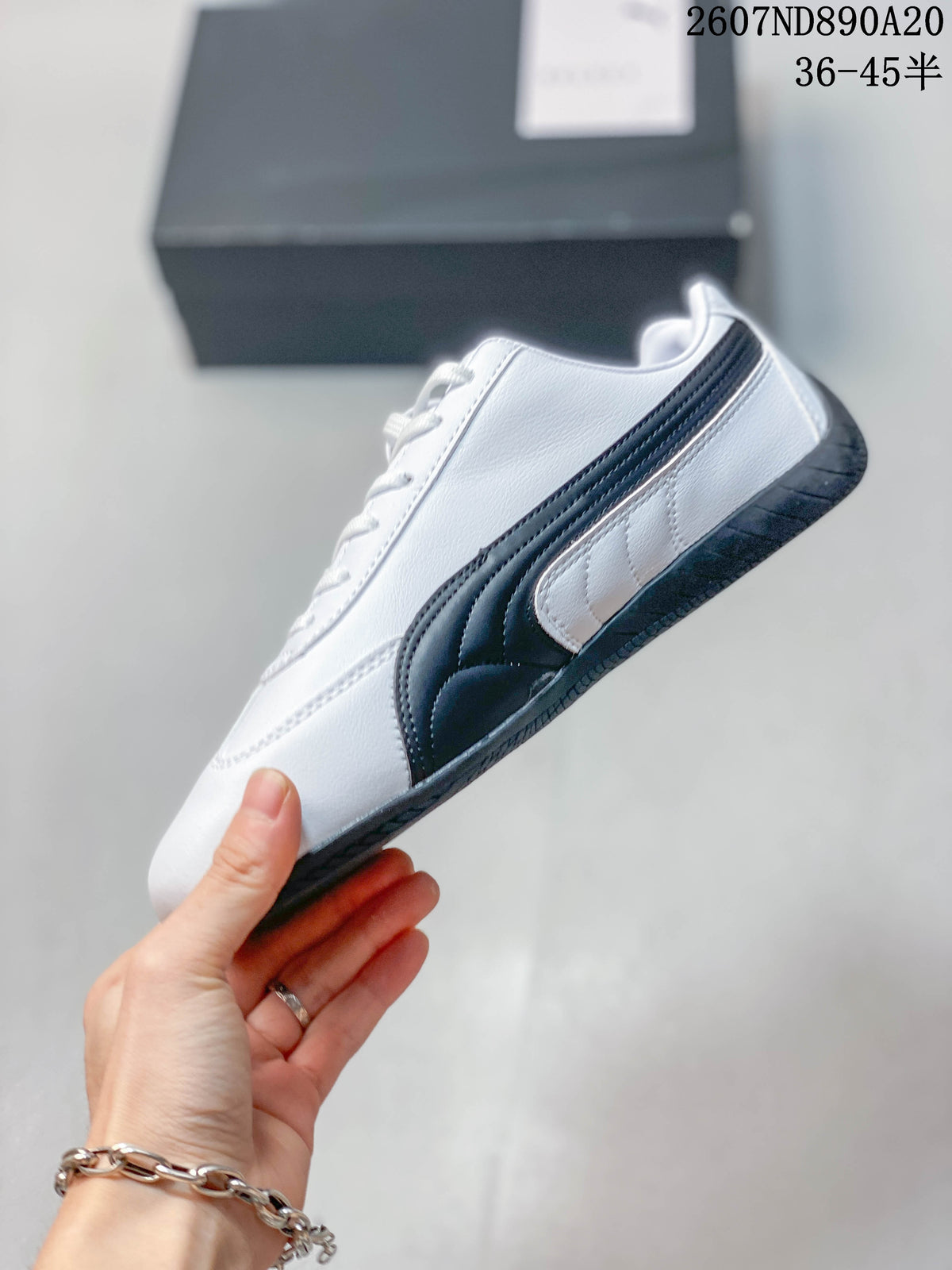 Side view of the white sneaker with black Puma Formstrip detailing