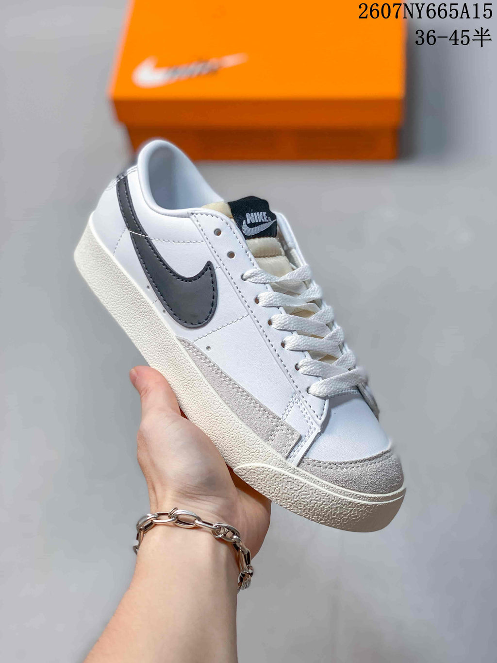 Angled side view showing the white upper, black Swoosh, gray overlays and textured sole.
