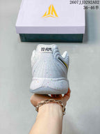Rear view of the white basketball shoe showing the padded heel, speckled details, and branded tongue pull.