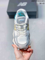 Top view of a white, grey and yellow New Balance 9060 sneaker with white laces and a 9060R tongue label.