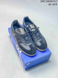 Black adidas Samba sneakers displayed on a blue shoebox, with gold-tone branding and a visible size range marking.