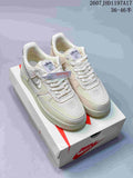 Pair of cream Stussy x Nike Air Force 1 '07 sneakers displayed on a shoebox, with woven uppers, embroidered Swoosh details, and visible product code text.