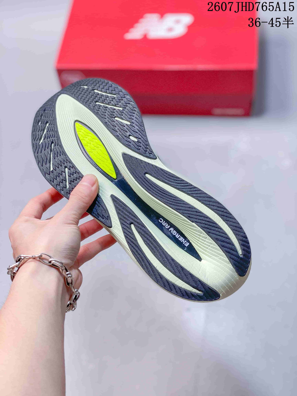 Close-up of the New Balance RC Elite outsole showing patterned dark rubber sections, light-colored midsole areas and a neon yellow insert.