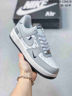 Three-quarter side view showing the white low-top silhouette, dark Swoosh details, and Supreme-branded heel accent.
