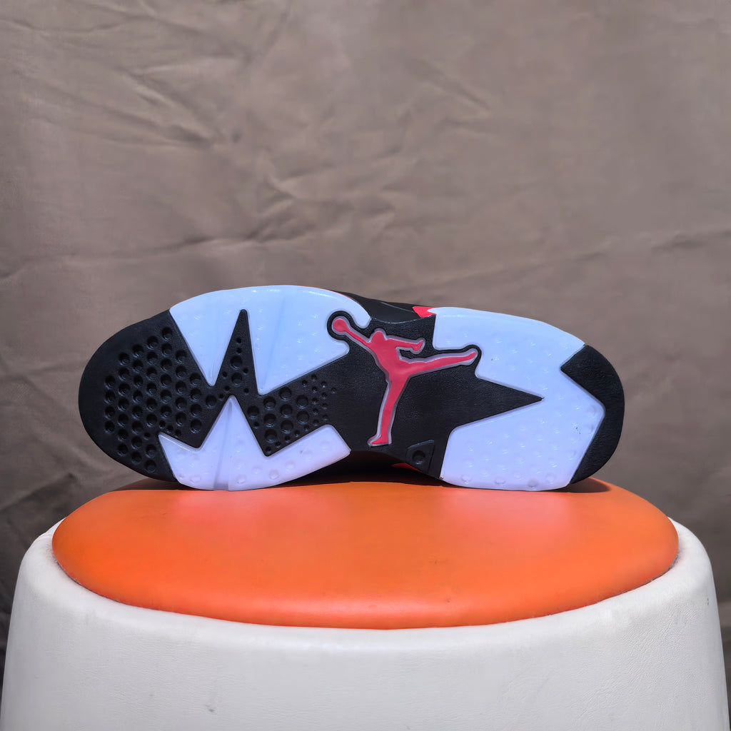 Outsole view showing black and white tread with red logo detail
