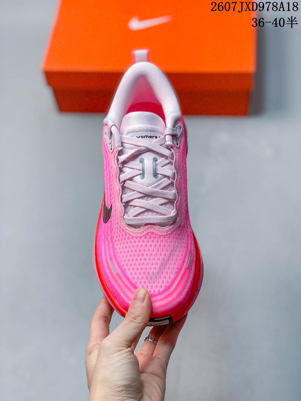 Top view of the pink sneaker showing the white laces, padded tongue, textured toe box and reflective-looking accents.