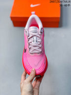 Top view of the pink sneaker showing the white laces, padded tongue, textured toe box and reflective-looking accents.