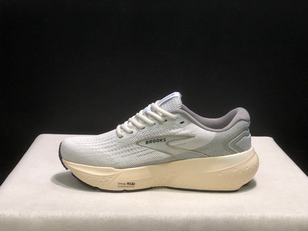 Outer side profile showing the Brooks side logo, gray heel panel, cream-colored midsole, and outsole detail.