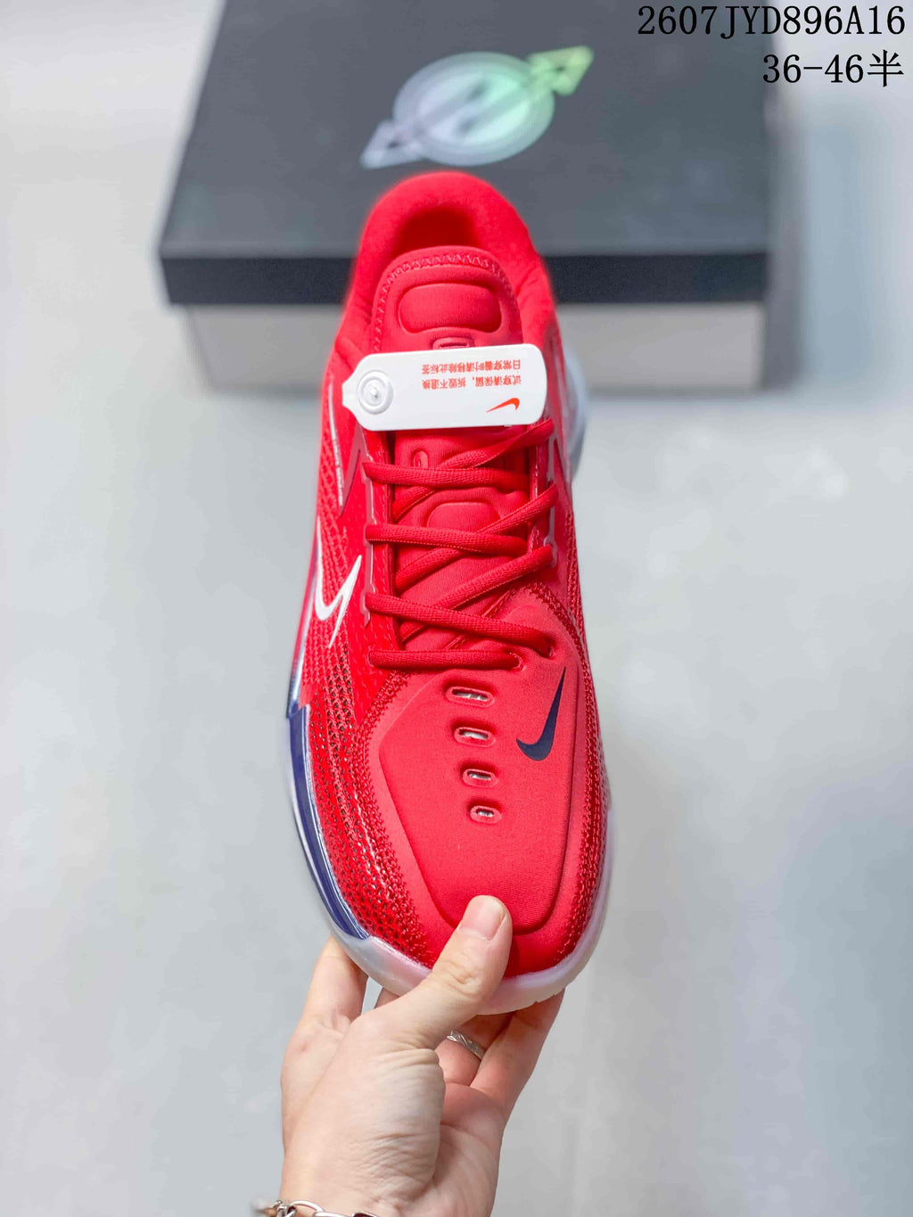 Top view of the red lace-up basketball shoe showing the padded tongue, eyelets and dark contrasting forefoot logo.